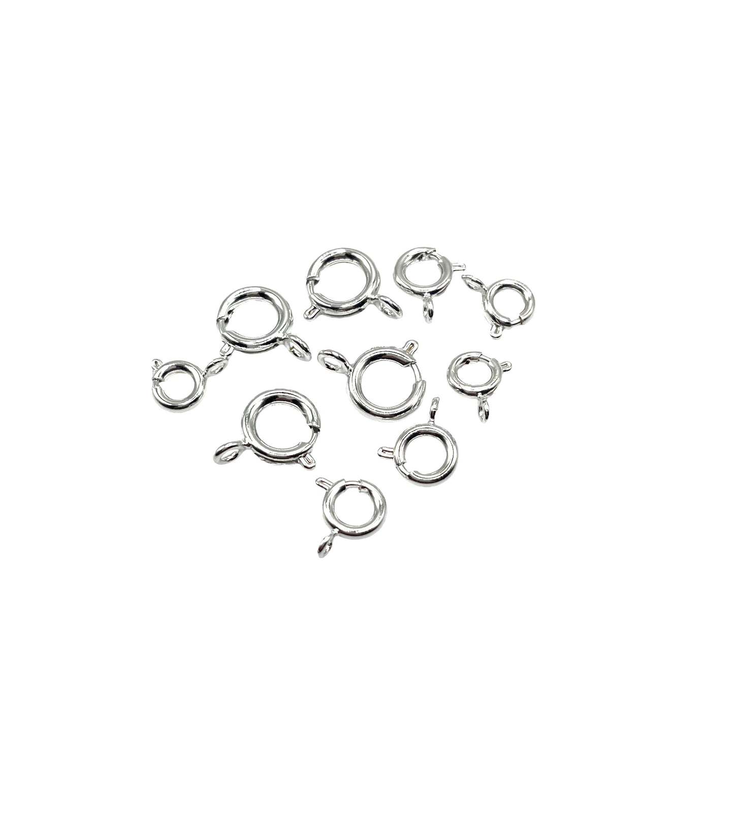 A collection of silver plated boltrings of various sizes arranged on a plain background.