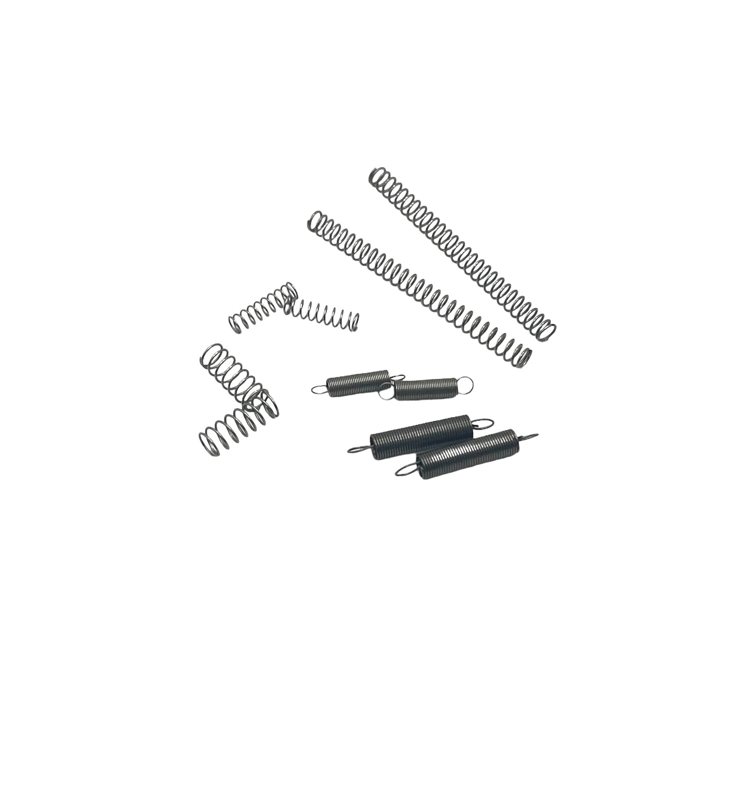 A selection of various sized spiral coil springs laid out on a white background, intended for use in clock and watchmaking.