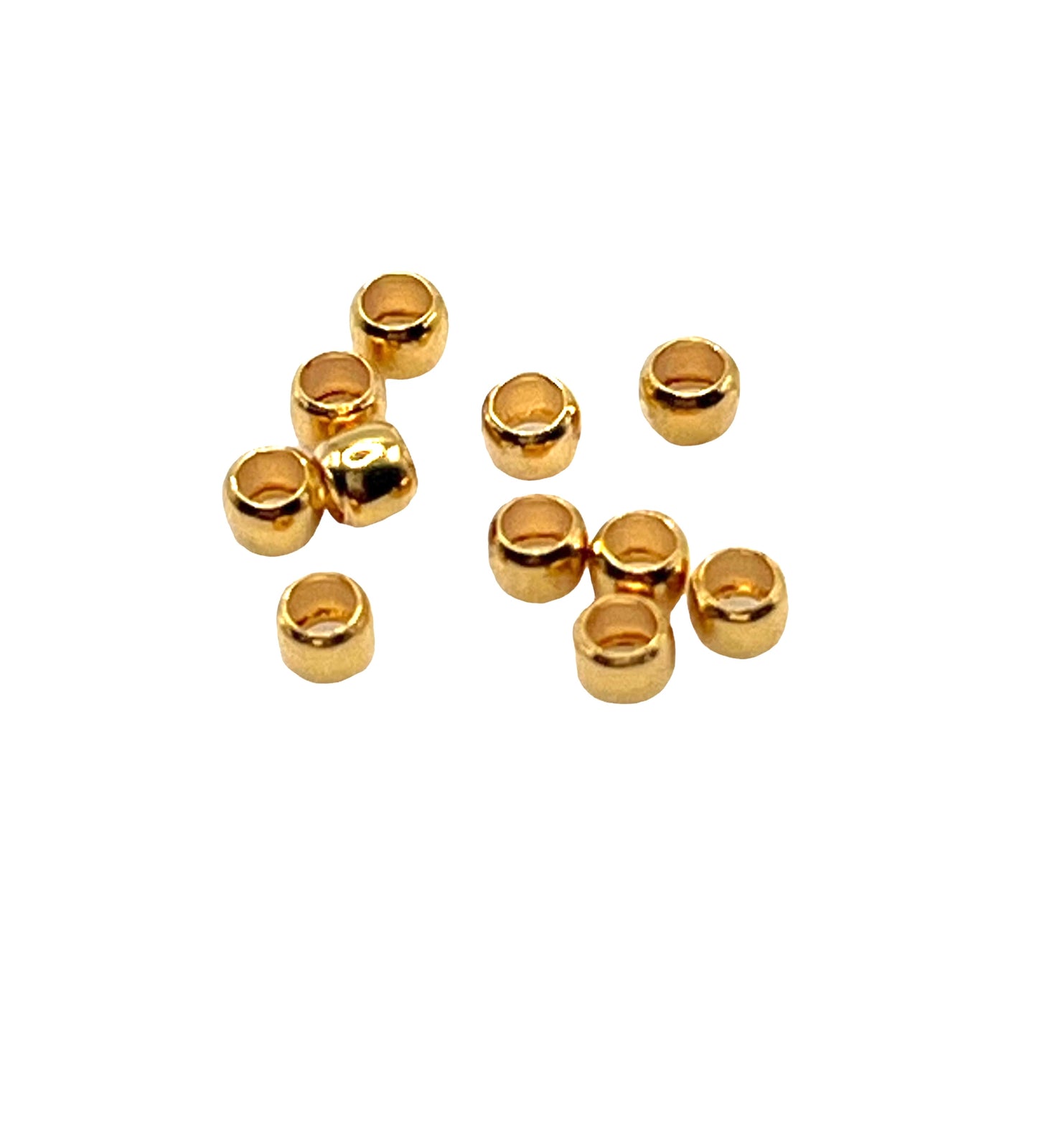 A collection of gold-colored bead crimps used for jewelry making, displayed on a white background