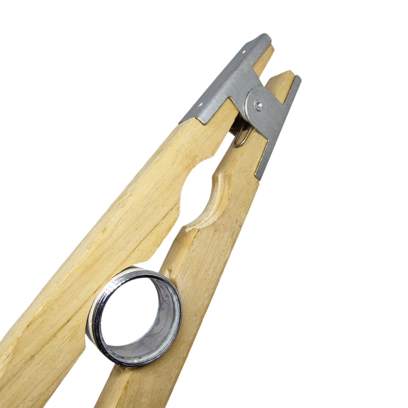 Close up of a wooden tweezer holding a silver colour ring
