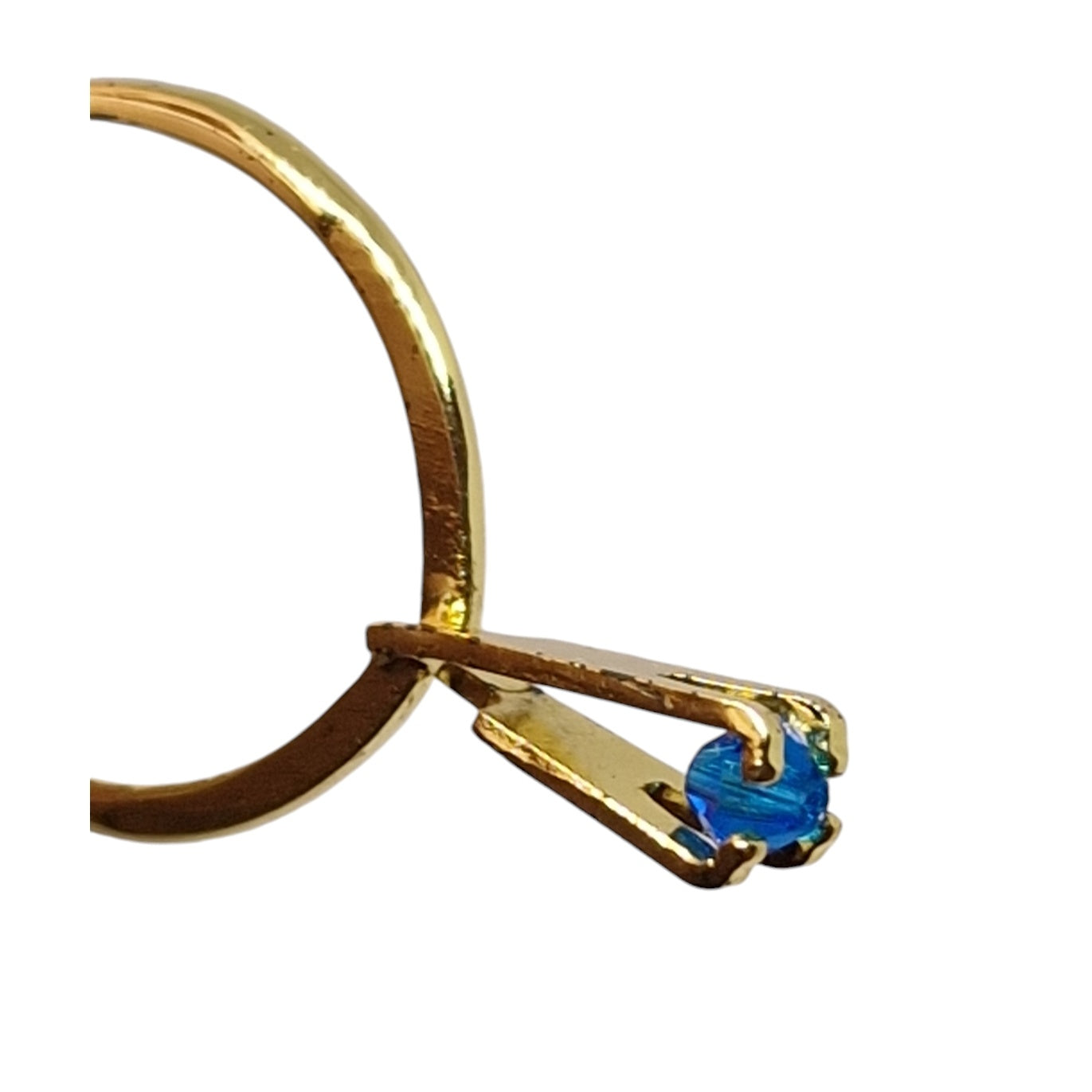 Gold ring setting holding a blue stone
