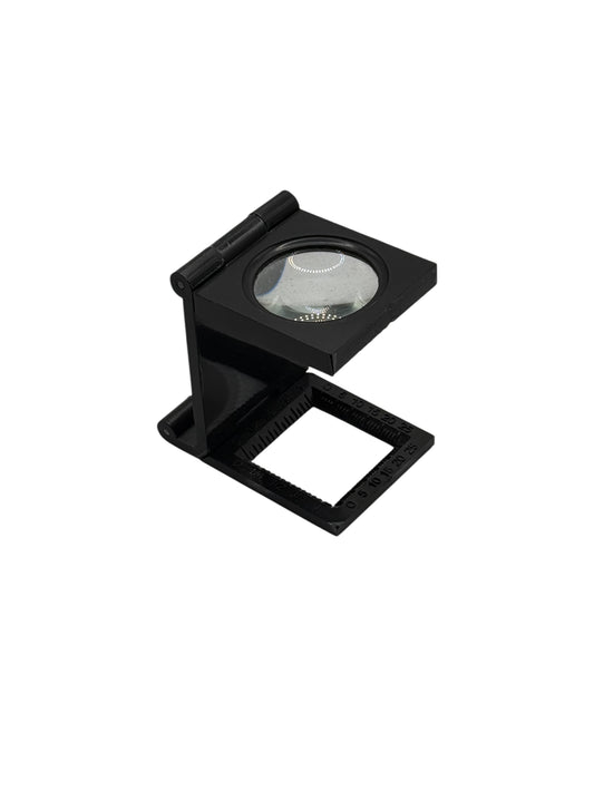 A black handheld magnifying tool with a metallic lens, designed for detailed work with small objects.