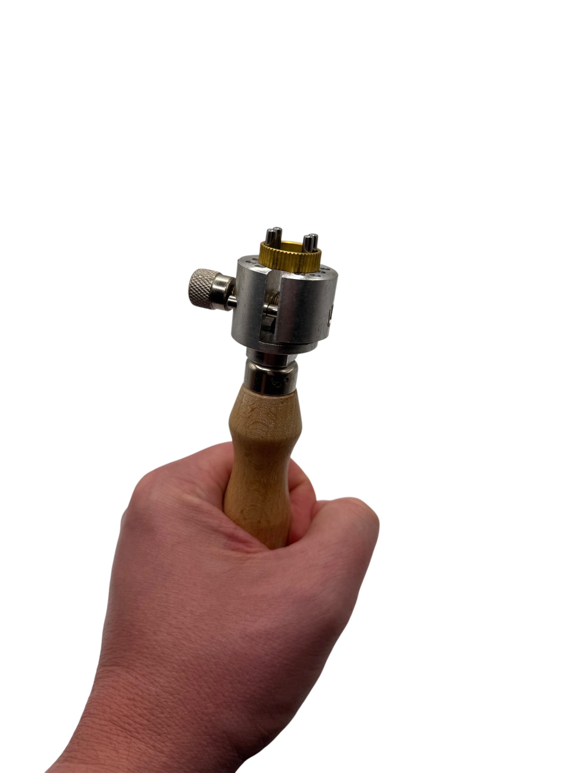 Hand holding a tool with a wooden handle and metal components on a white background