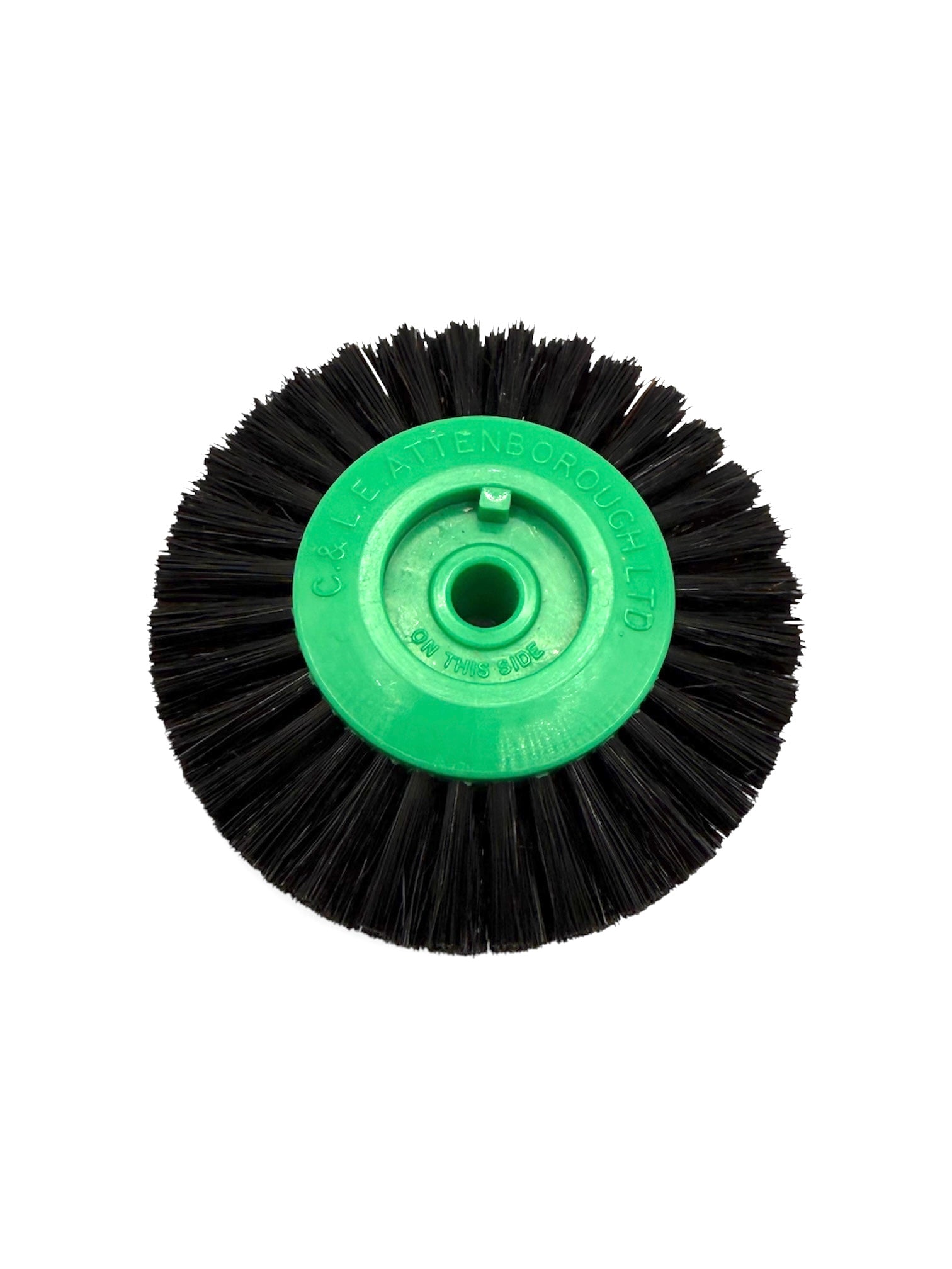 Circular black bristle brush with a green plastic centre