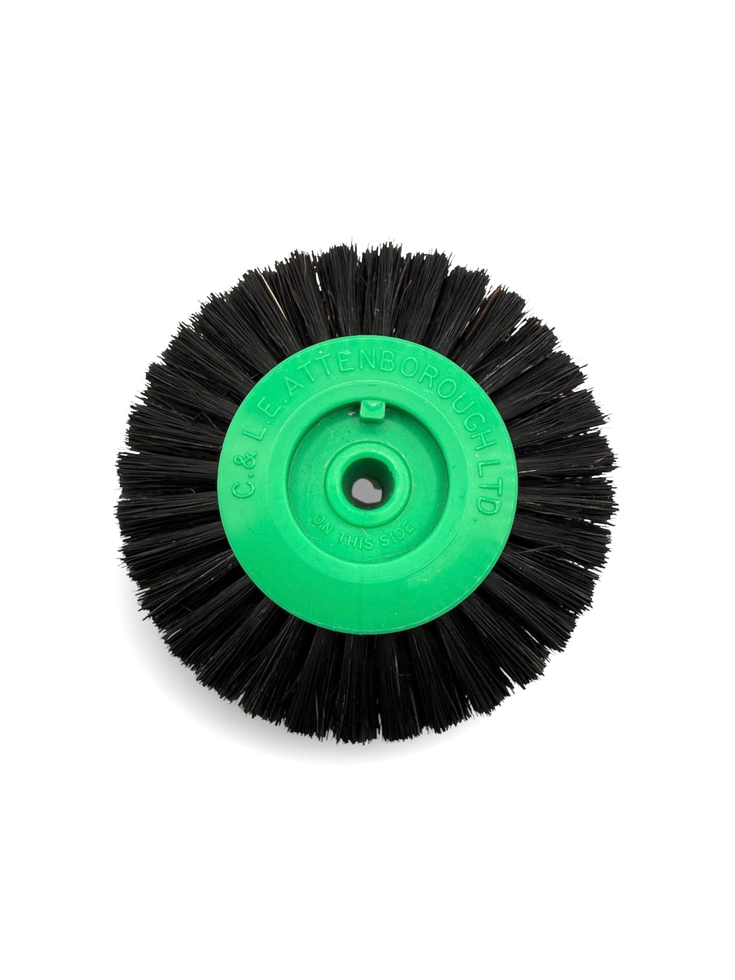 Circular black bristle brush with a green plastic centre