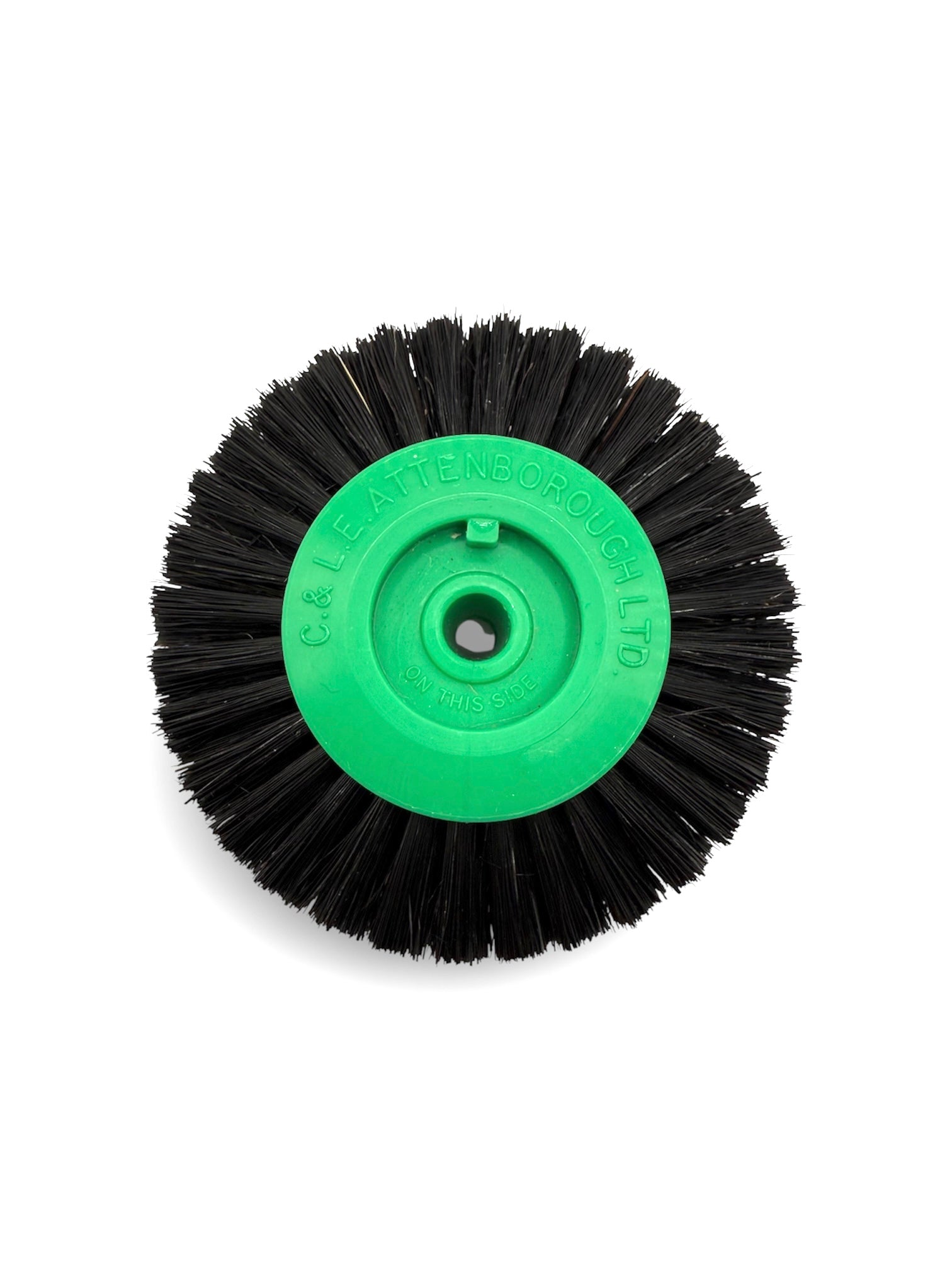 Circular black bristle brush with a green plastic centre