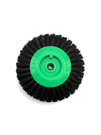 Circular black bristle brush with a green plastic centre