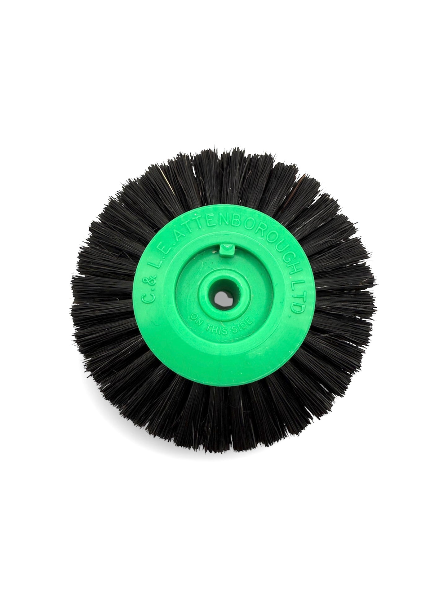 Circular black bristle brush with a green plastic centre
