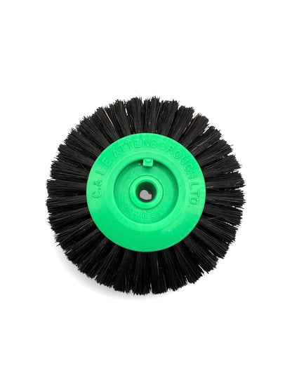 Circular black bristle brush with a green plastic centre