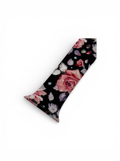 A long, narrow black accessory with a floral print featuring pink and white roses, purple accents, and small metallic studs, shown on a plain white background.