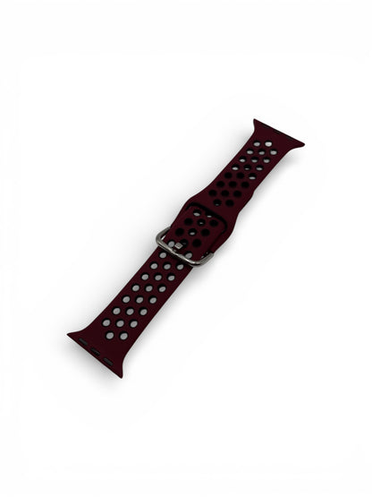 A dark burgundy perforated silicone watch band with a silver metal buckle, shown diagonally on a plain white background.