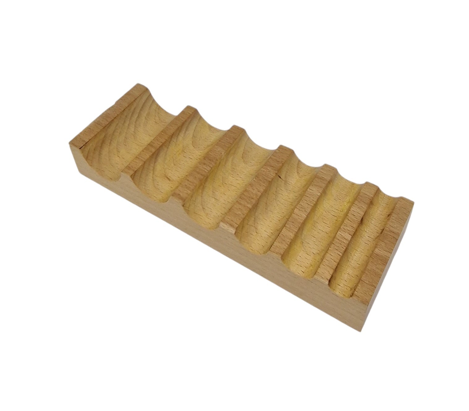 A wooden swage block with semi-circular grooves on one side and a flat surface on the other, used for bending and shaping metal in jewelry making.