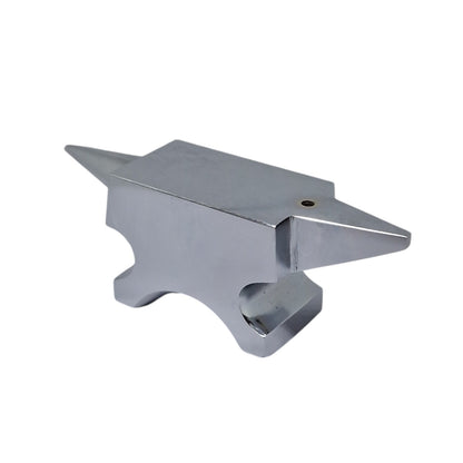 A polished silver anvil with one round horn and one flat base with a hole in the top face for riveting work.