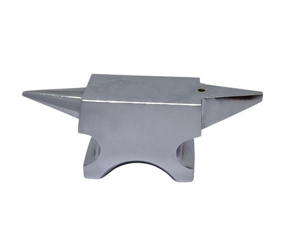 A polished silver anvil with one round horn and one flat base with a hole in the top face for riveting work.