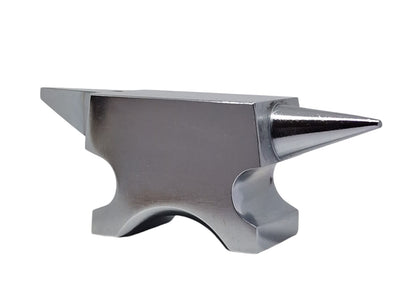 A polished silver anvil with one round horn and one flat base with a hole in the top face for riveting work.