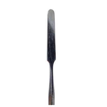 A single stainless steel wax carving tool with a straight blade and ribbed handle.
