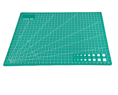 A green A4 cutting mat with grid lines and measurements marked for precision cutting.