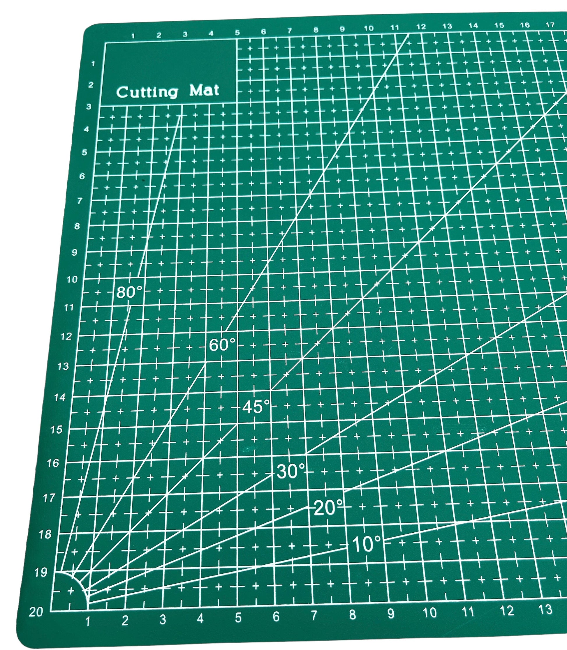 A green A4 cutting mat with grid lines and measurements marked for precision cutting.